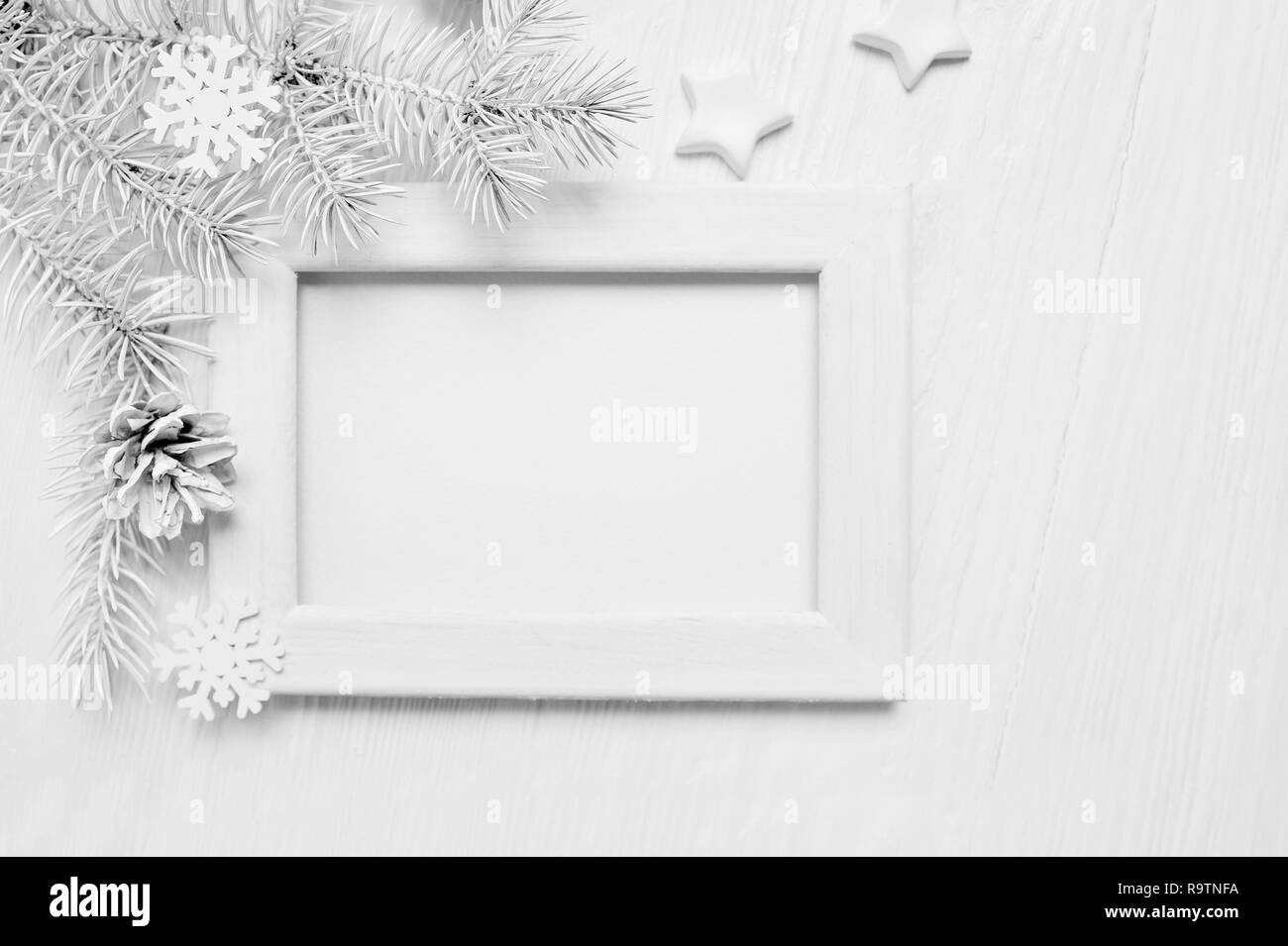 Mockup Natale albero bianco telaio in legno con posto per il vostro testo, decorativi stelle, fiocchi di neve e il cono. Appartamento giaceva su un bianco sullo sfondo di legno. Vista superiore Foto Stock