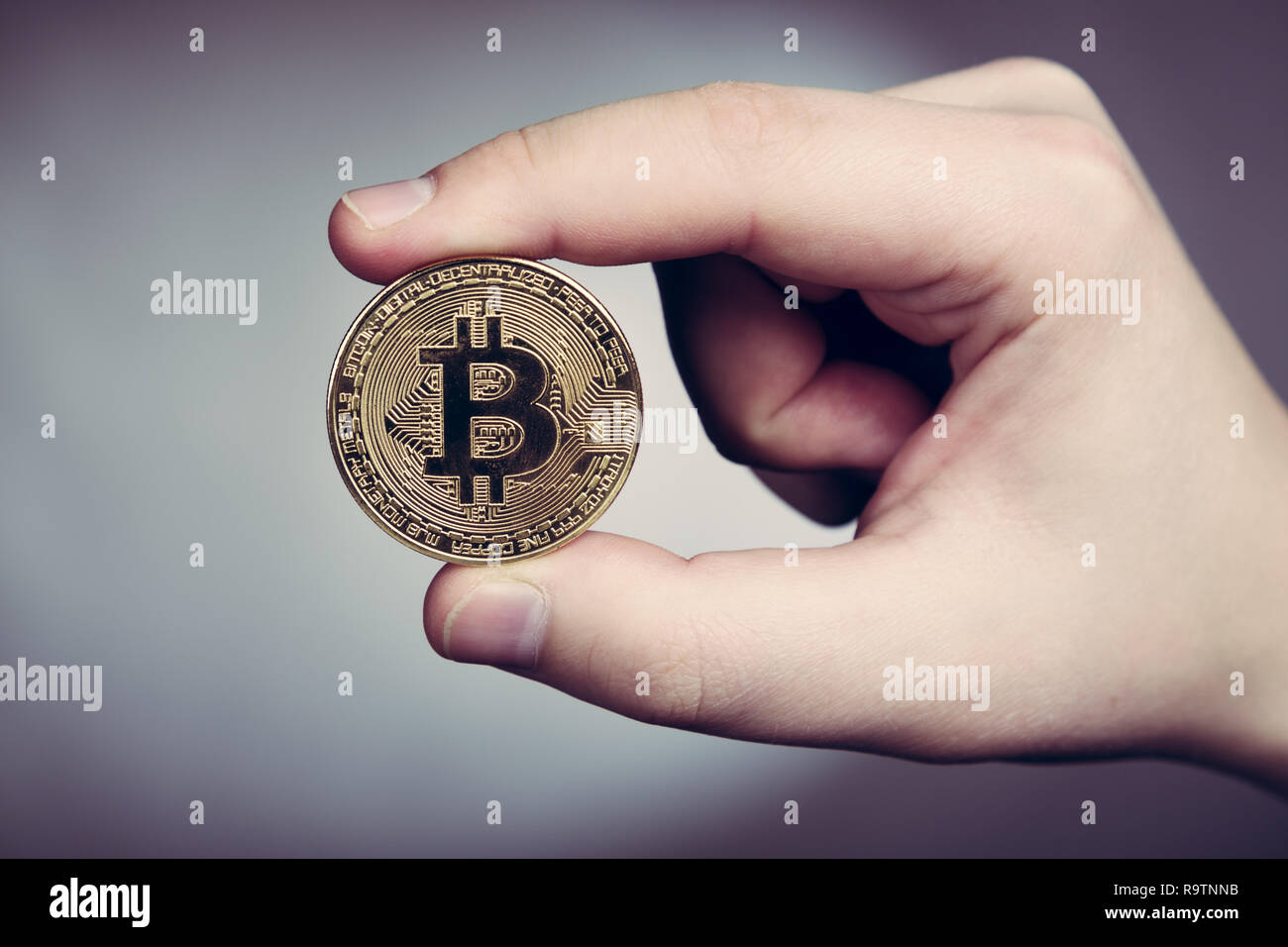 Mantenendo bitcoin cryptocurency in mano Foto Stock