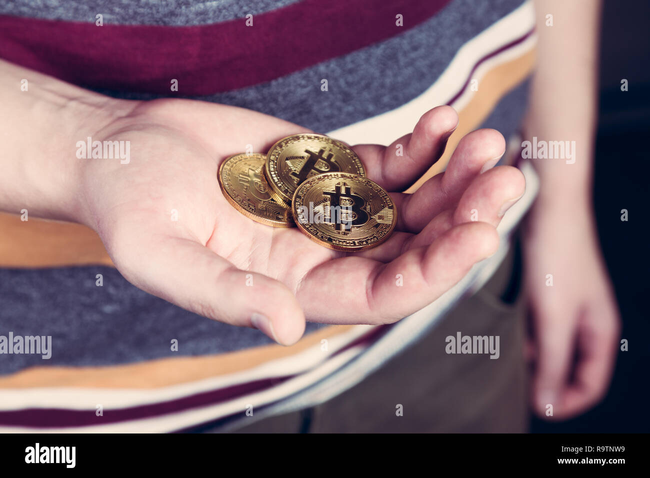 L uomo è mantenere bitcoin btc cryptocurency moneta in oro in mano Foto Stock