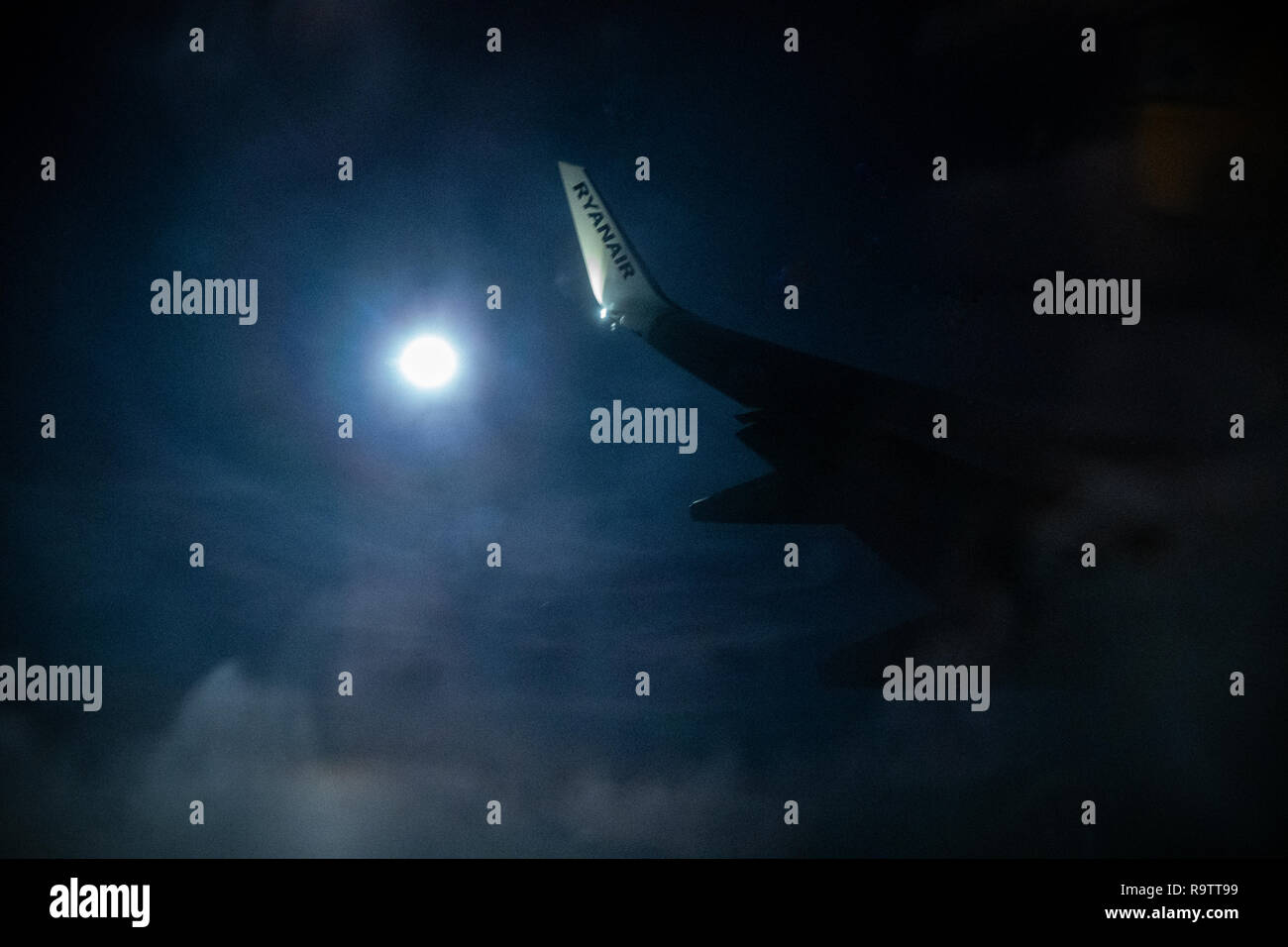 Ryanair punta ala accesa in un cielo di notte da una luna piena Foto Stock