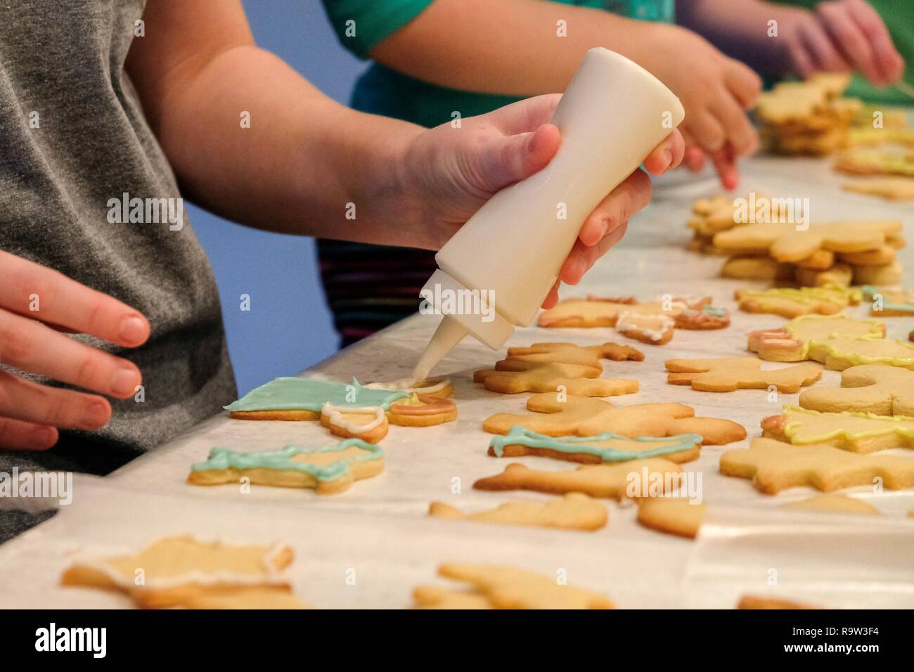 I bambini sono la decorazione di biscotti di Natale in preparazione per la Santa dell'arrivo. Foto Stock