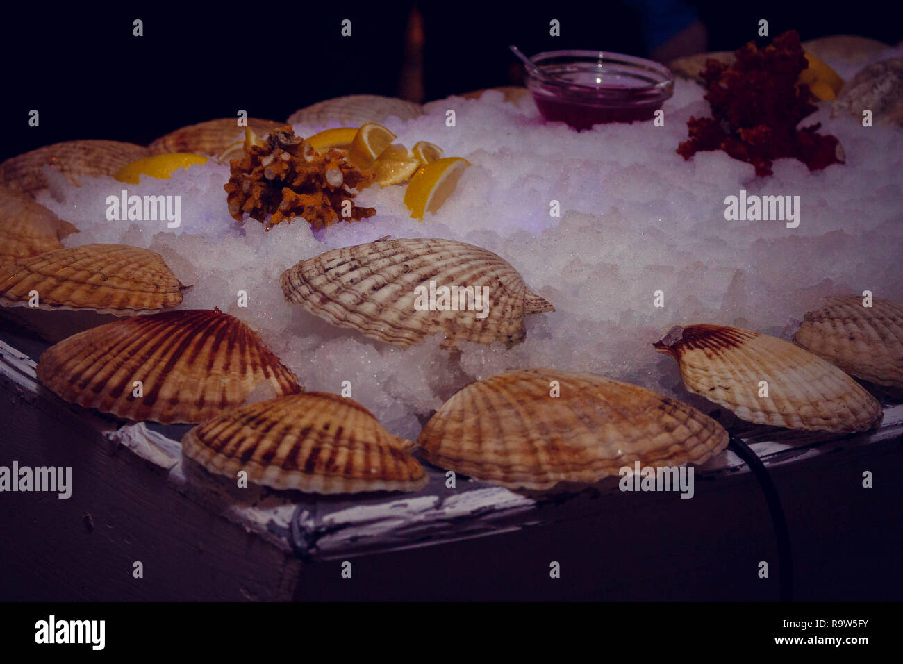 Ostriche con il condimento sul tavolo con ghiaccio. Corporativo Foto Stock