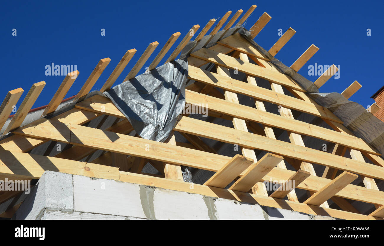 Installazione di travi in legno, registri eaves, legname su casa nuova costruzione tetti. Foto Stock