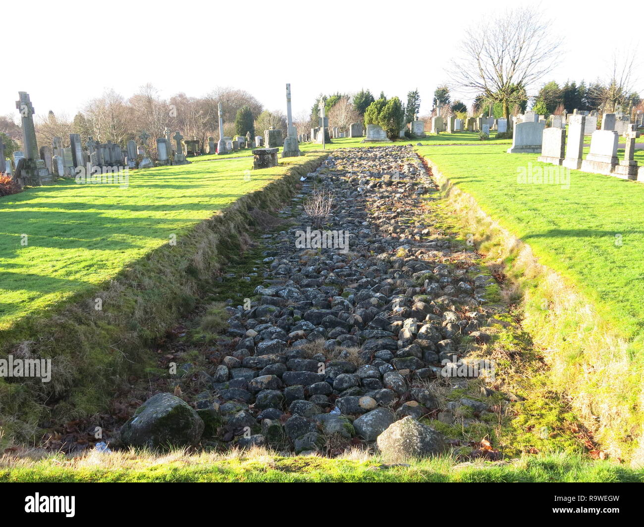 Due sezioni di base della pietra del bastione del Antonine Wall sono conservati presso il Nuovo Cimitero Kilpatrick, dall'occupazione romana della Scozia Foto Stock