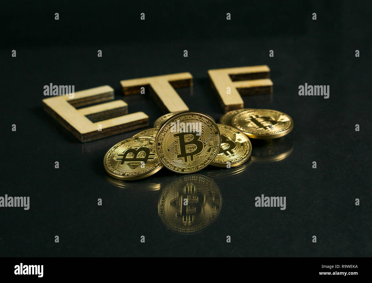 Moneta Bitcoin con ETF testo posto sul pavimento di legno, concetto di entrare il denaro digitale Fondo. Foto Stock