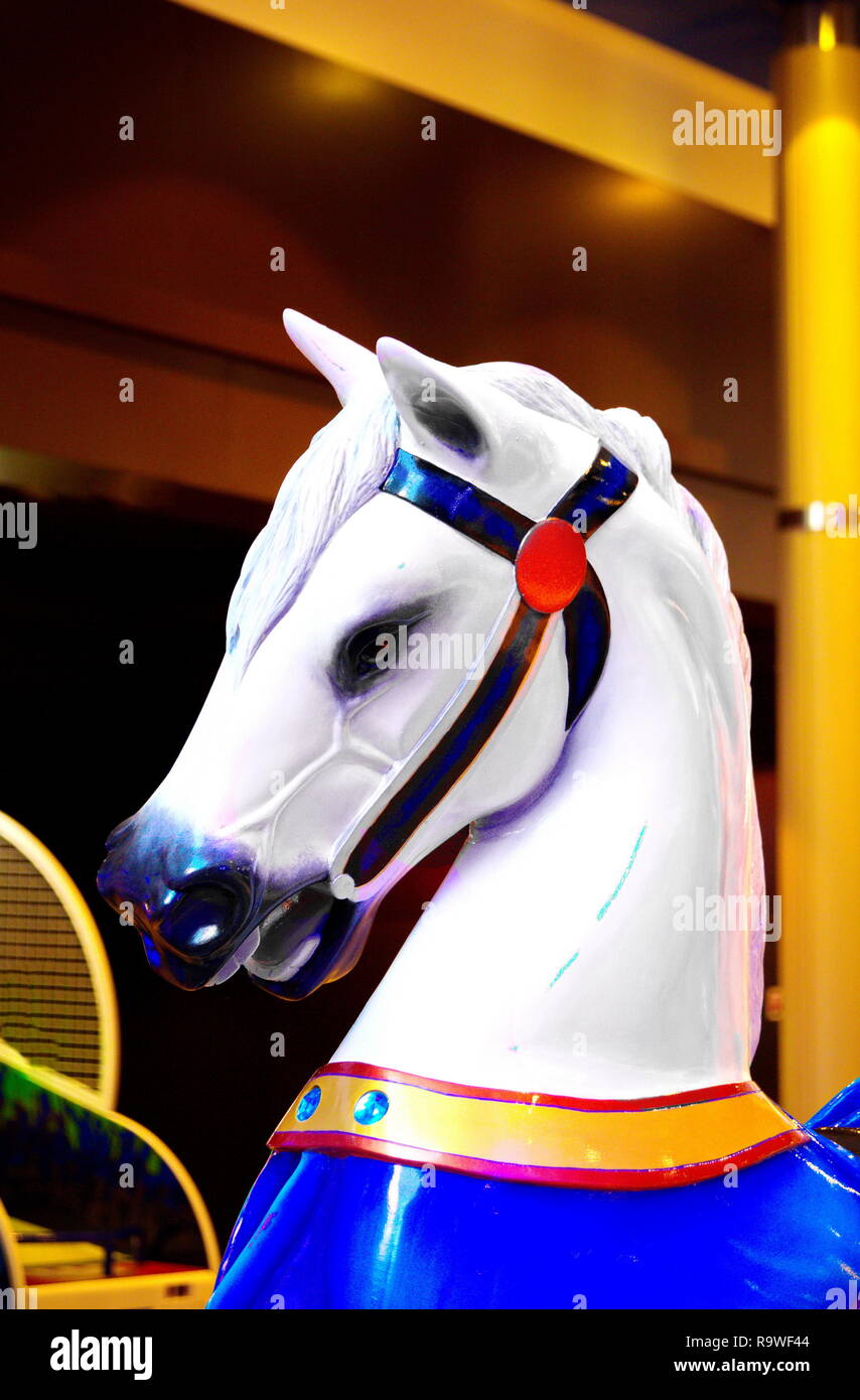 Un dipinto e coloratissima giostra cavallo in un parco di divertimenti Foto Stock