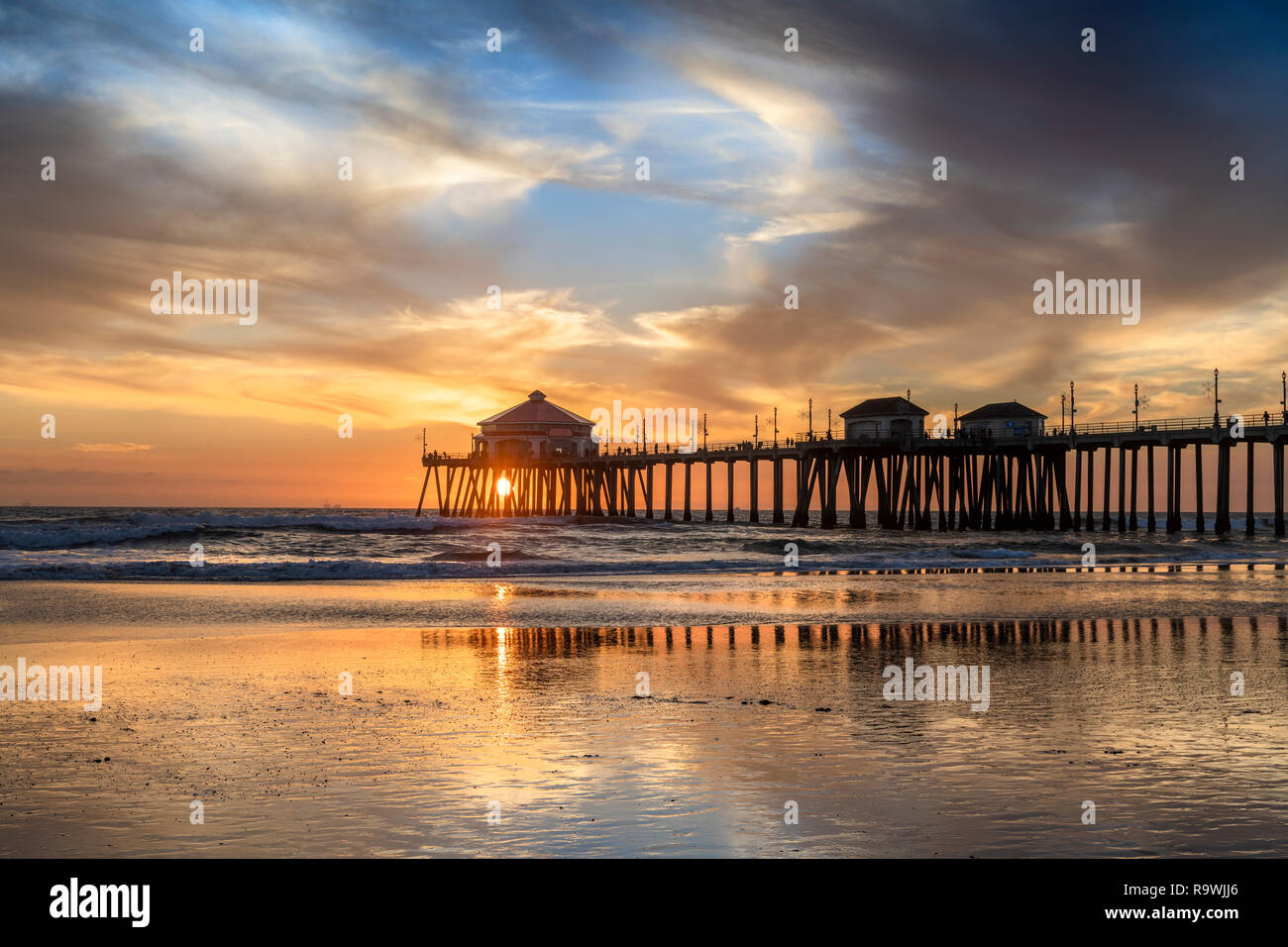 Paesaggio surreale come il sole tramonta sotto l'orizzonte lungo Huntington Beach, colata di un bagliore bellissimo e tranquillo paesaggio. Foto Stock