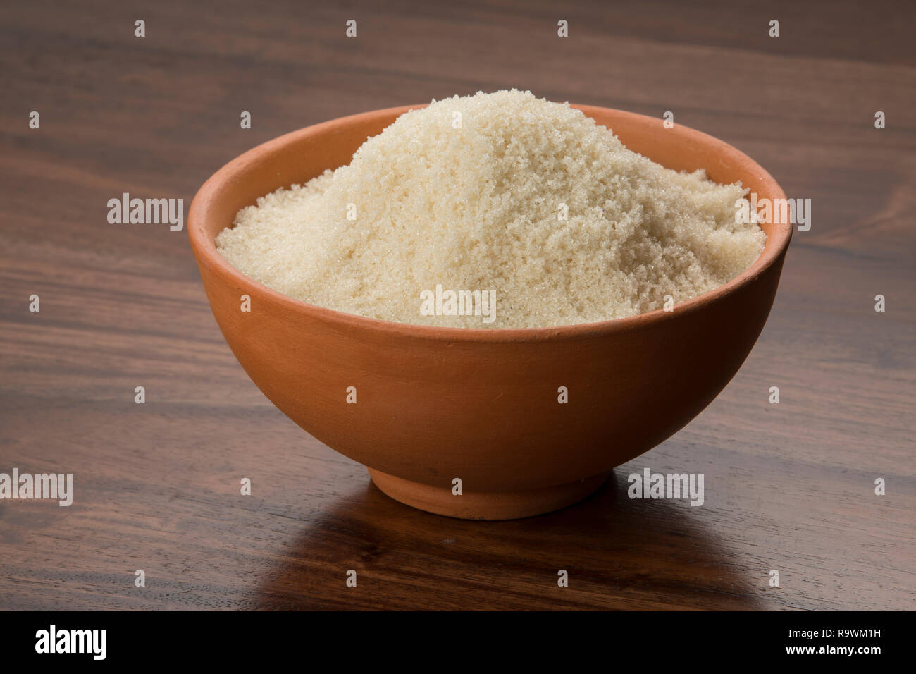 Cibo: materie non raffinato lo zucchero di canna nel recipiente di terracotta su sfondo di legno Shot in Studio Foto Stock