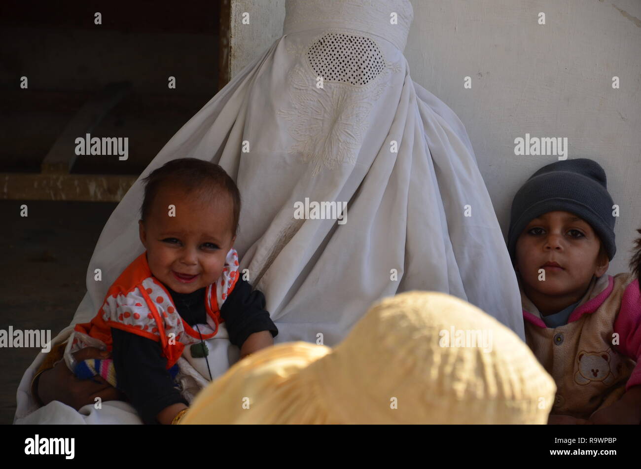 Una madre con i suoi due bambini in un ospedale di Bannu, KPK, Pakistan Foto Stock