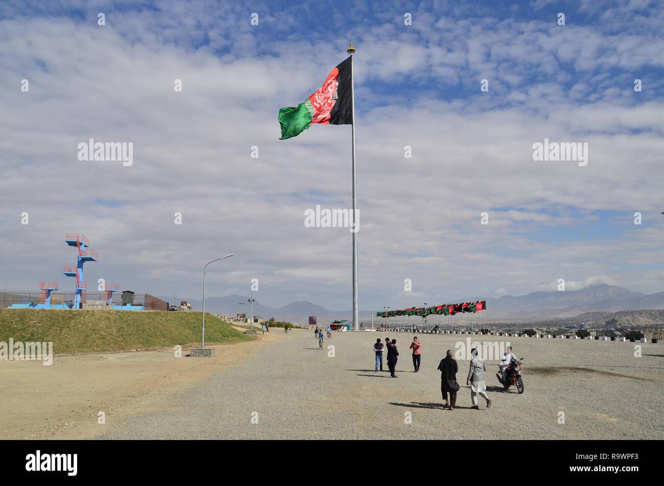 La gente a piedi dalla bandiera dell'Afghanistan in un parco a Kabul. Foto Stock
