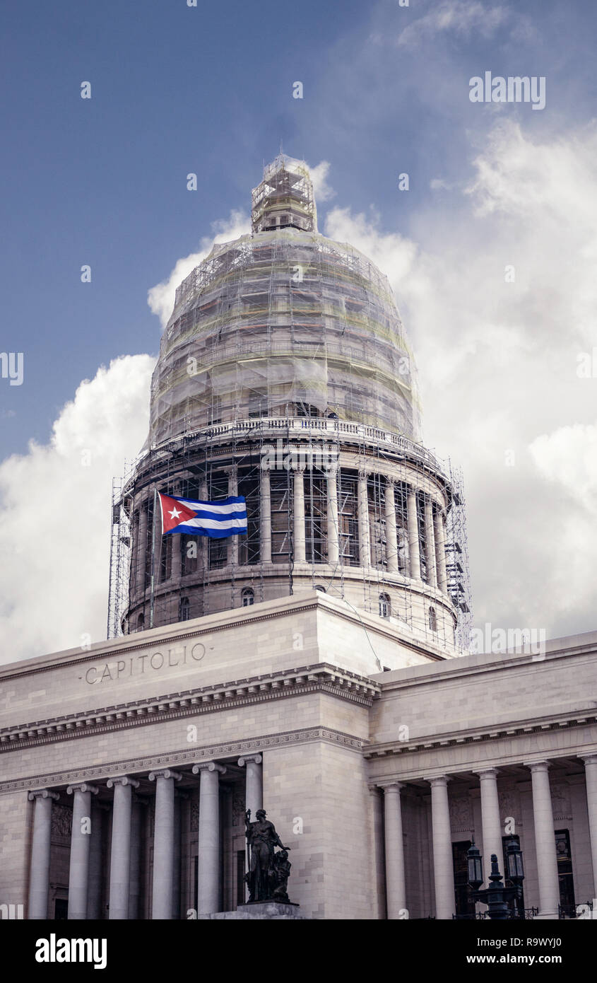 Capitol Building del governo cubano nel centro di Avana con la bandiera di Cuba nella parte anteriore e un cielo nuvoloso in background. Foto Stock