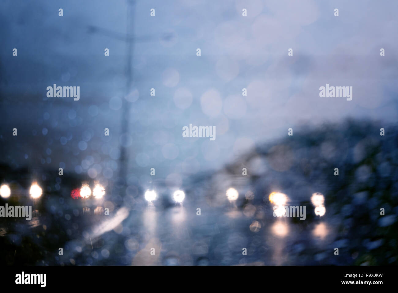 Il traffico pesante in giornata piovosa con vista su strada all'interno del finestrino con gocce di pioggia bokeh di fondo. Foto Stock