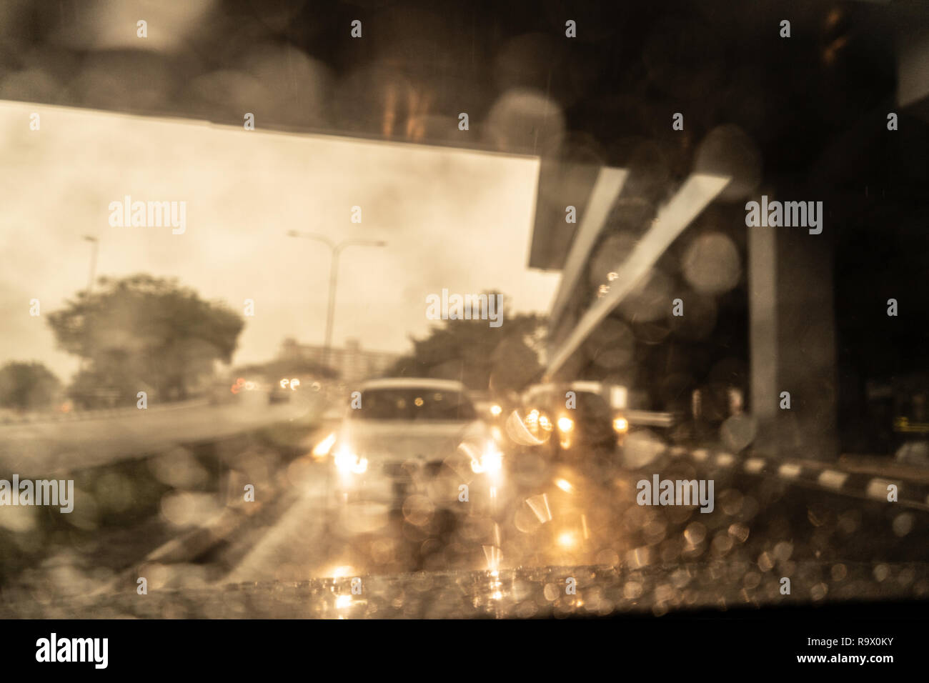 Il traffico pesante in giornata piovosa con vista su strada all'interno del finestrino con gocce di pioggia. Foto Stock