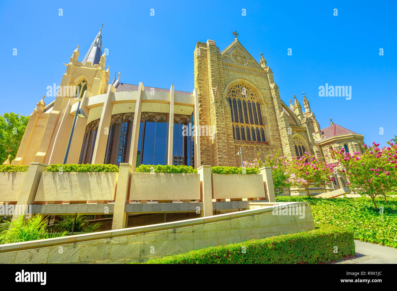 Vista laterale della Cattedrale di Santa Maria con il vetro macchiato in Perth, Western Australia. Il giardino intorno alla cattedrale in stile neogotico. Durante la stagione estiva. Blue sky. I punti di riferimento in Perth capitale di WA. Foto Stock