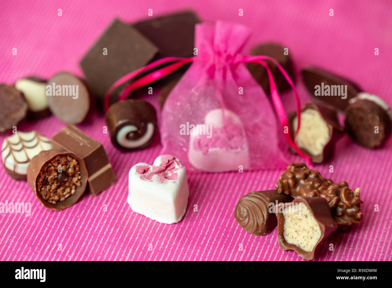 Cioccolatini dolce su un sfondo rosa Foto Stock