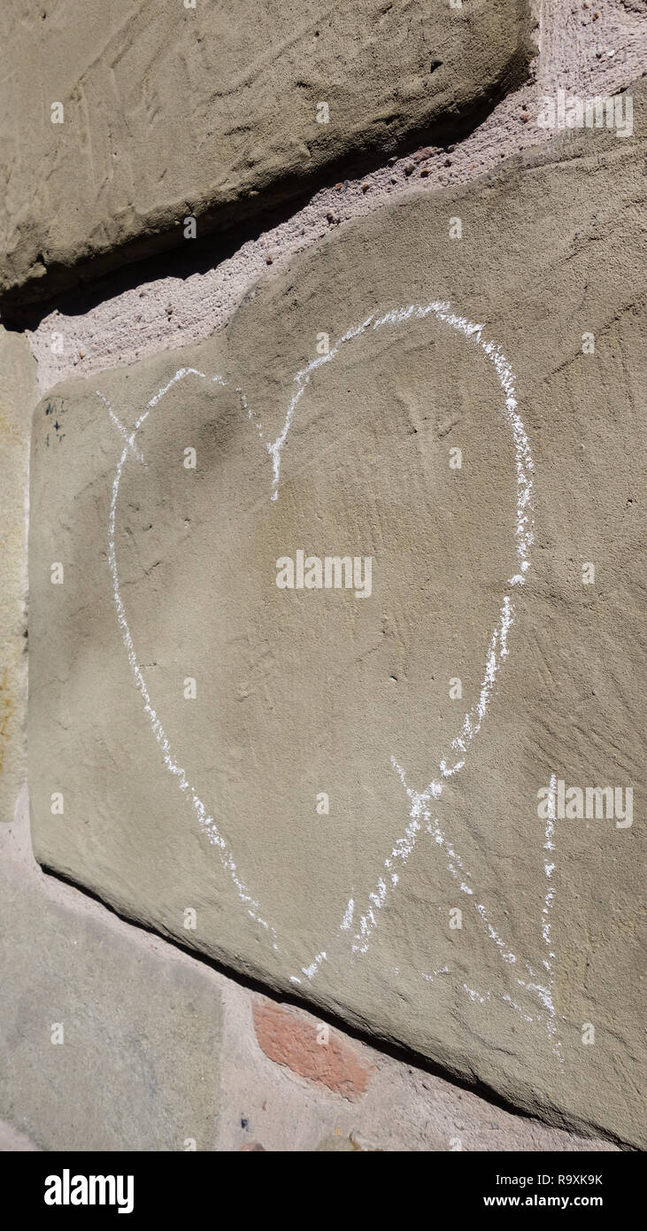 Cuore tracciato in bianco gesso su una pietra arenaria muro di mattoni Foto Stock