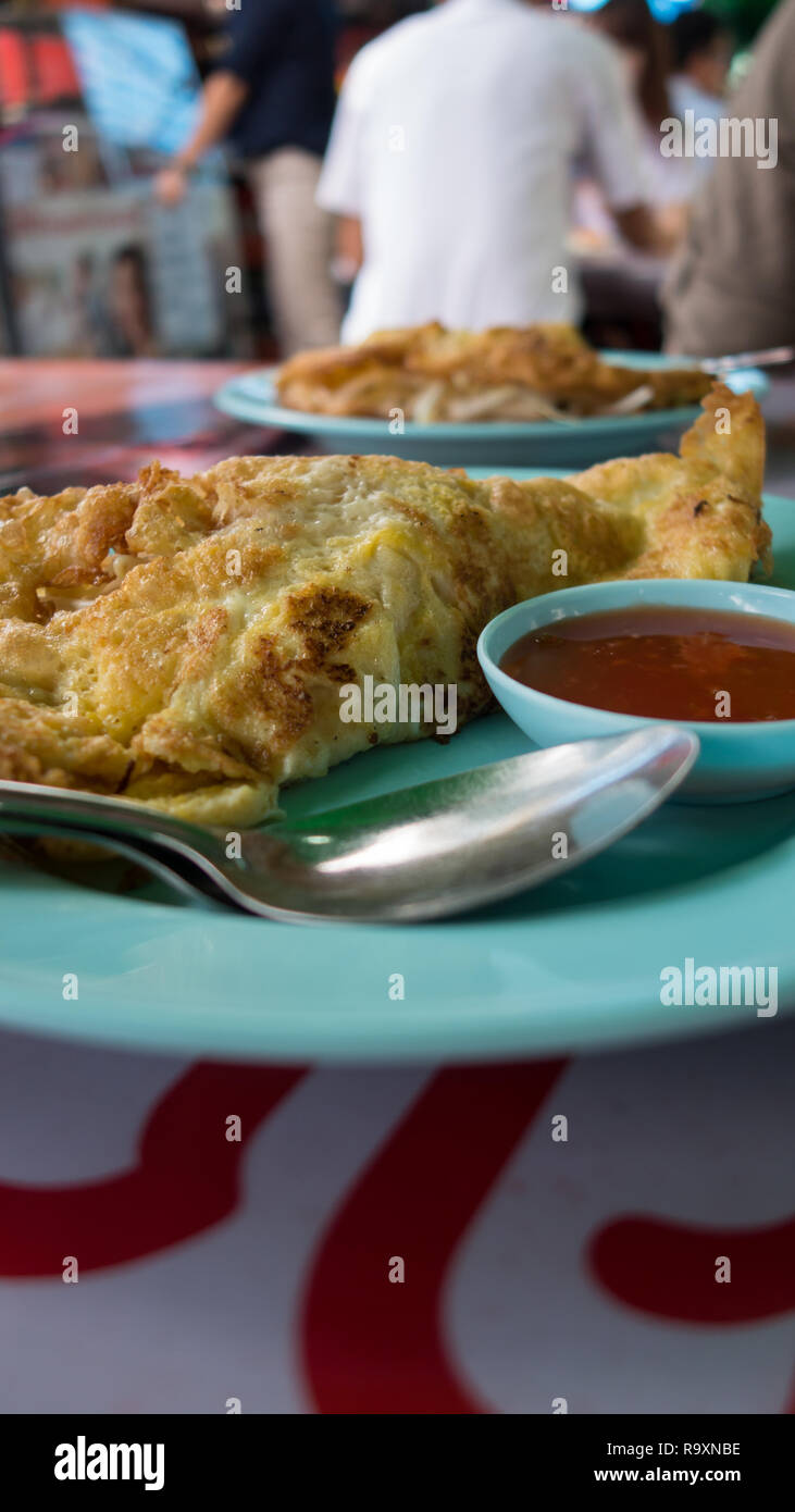 La prima colazione a Bangkok, Thailandia, frittata con salsa di peperoncino su una piastra di turchese Foto Stock