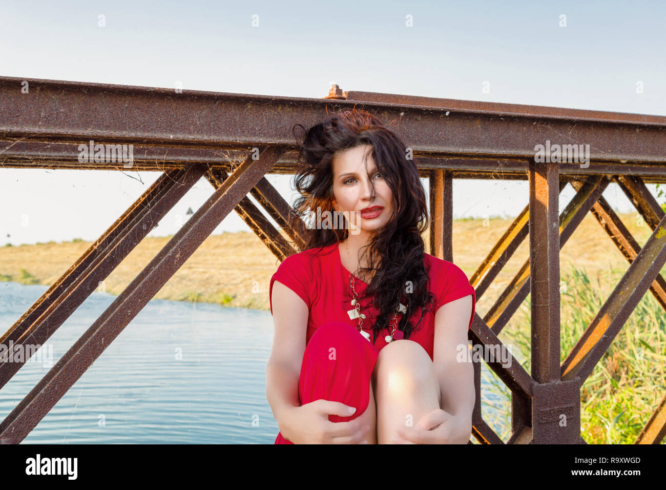 Settentrionale Europeo ragazza seduta sul vecchio ponte arrugginito in campagna di Ferrara Foto Stock