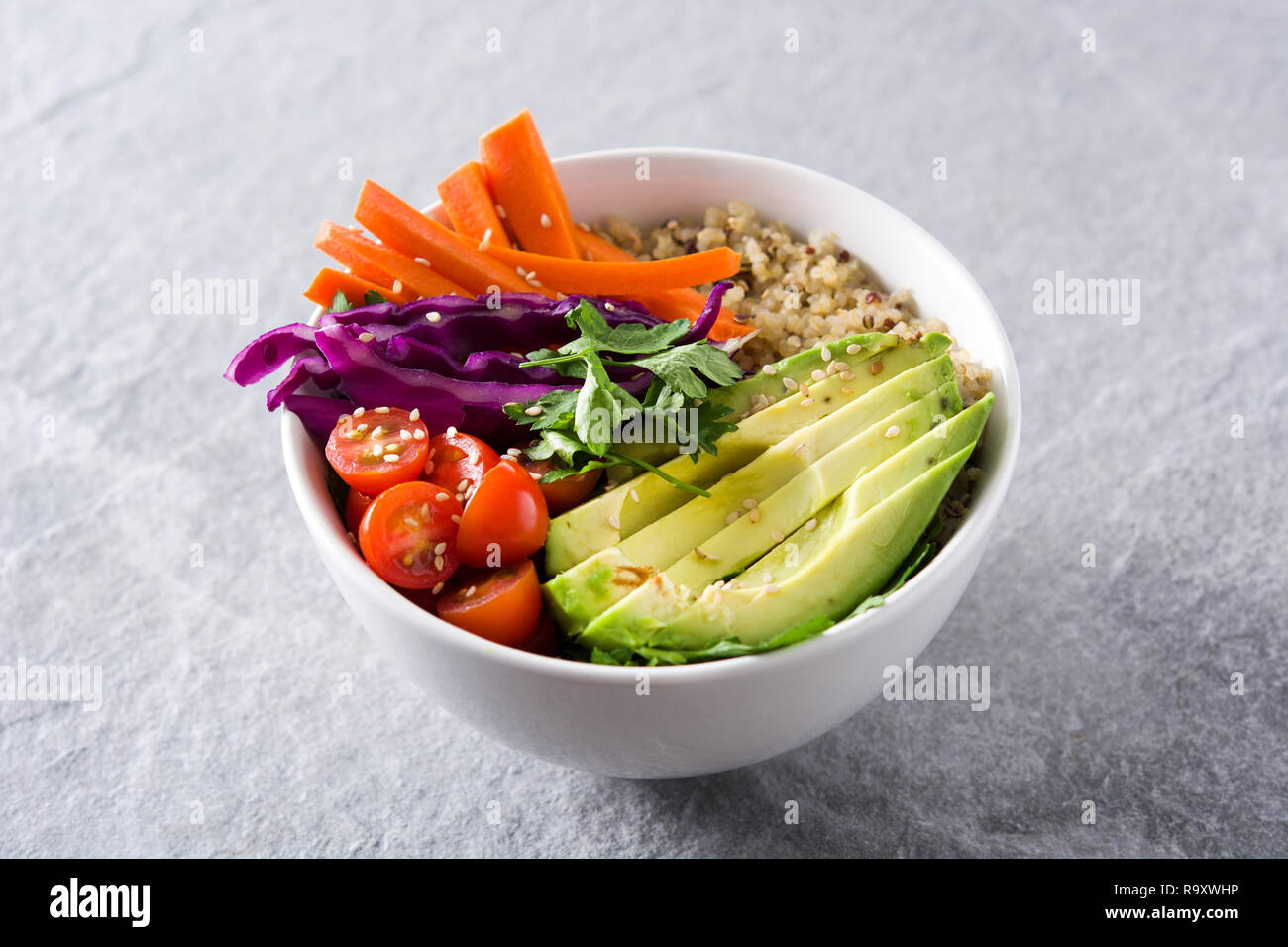 Buddha vegano ciotola con fresche verdure crude e quinoa su sfondo grigio Foto Stock