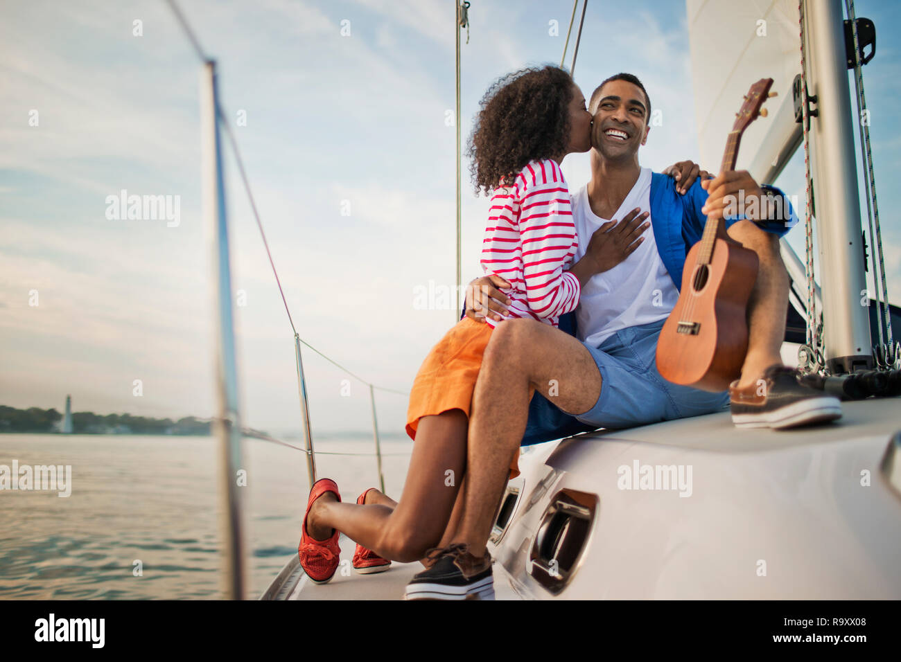 Felice coppia giovane divertendosi l'ukulele mentre la vela. Foto Stock