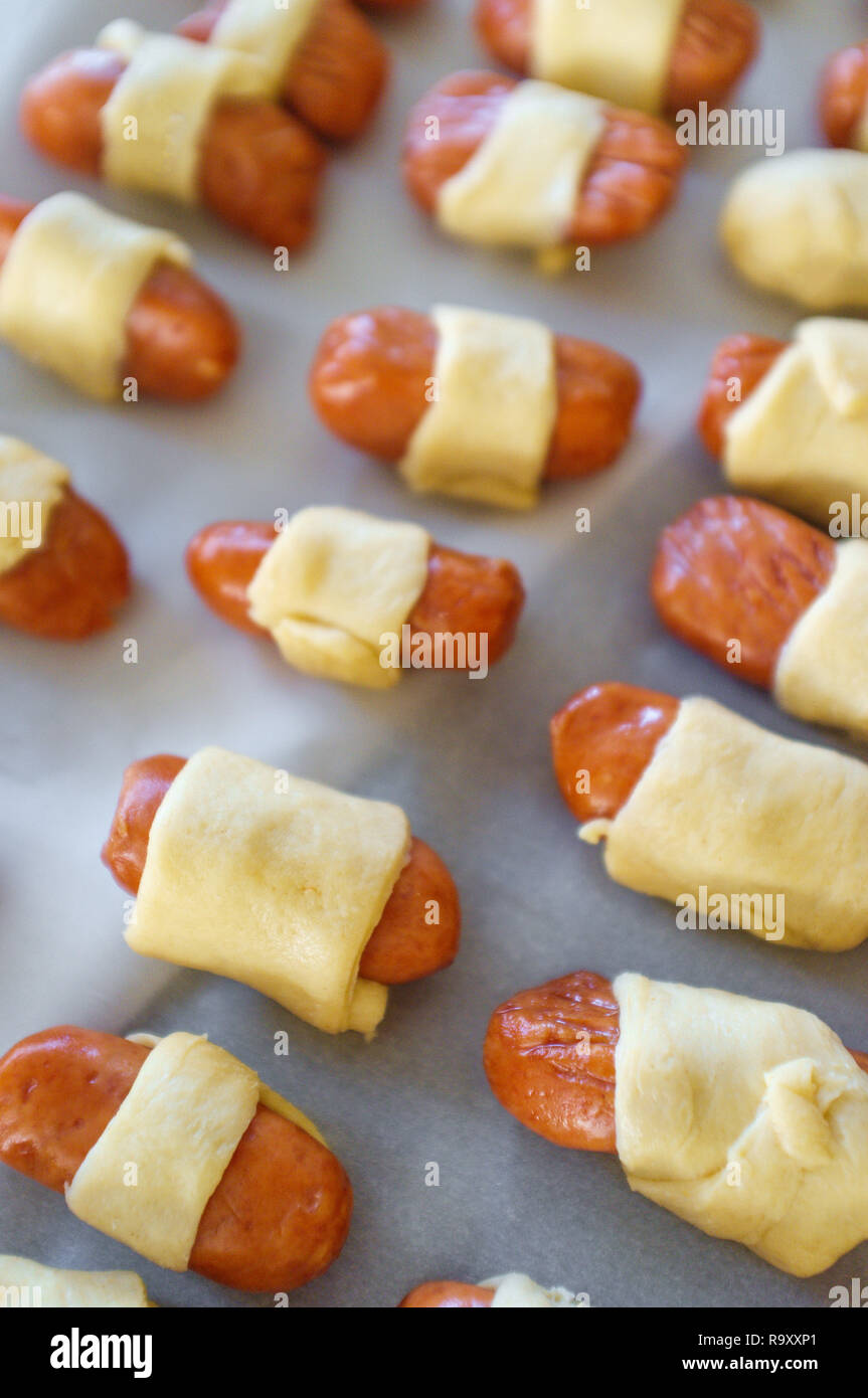 Maiale cruda in una coperta hotdog avvolto in pasta croissant pronto per essere cotto al forno Foto Stock