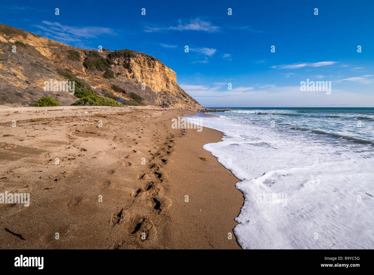 Alte scogliere che circondano Rancho Palos Verdes Beach con una scia di orme nella sabbia, Rancho Palos Verdes, California Foto Stock