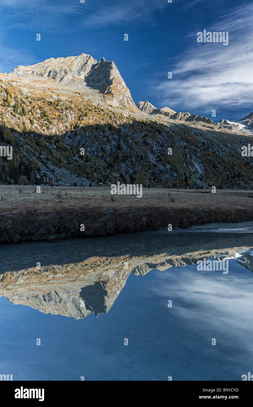 Paesaggio autunnale nelle Alpi, riflettere nel fiume, Italia Foto Stock
