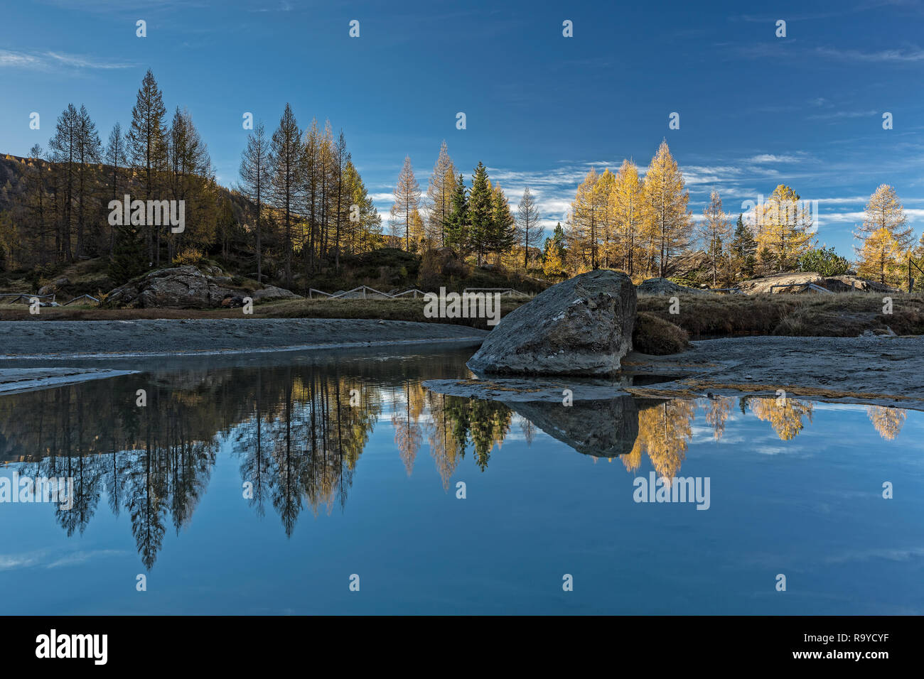 Paesaggio autunnale nelle Alpi, riflettere nel fiume, Italia Foto Stock
