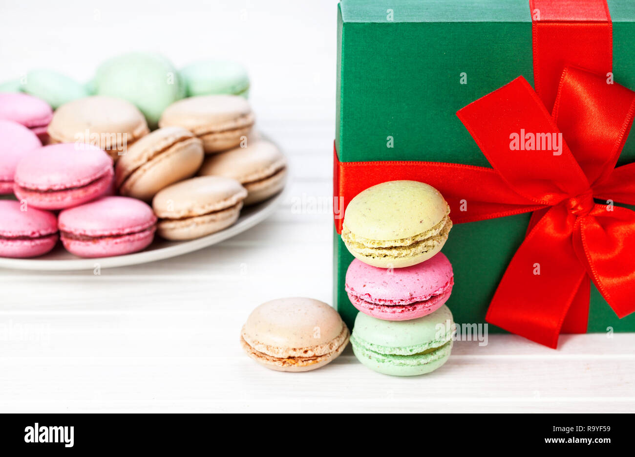 Colorati macarons francese nei pressi di Natale scatola su sfondo bianco Foto Stock