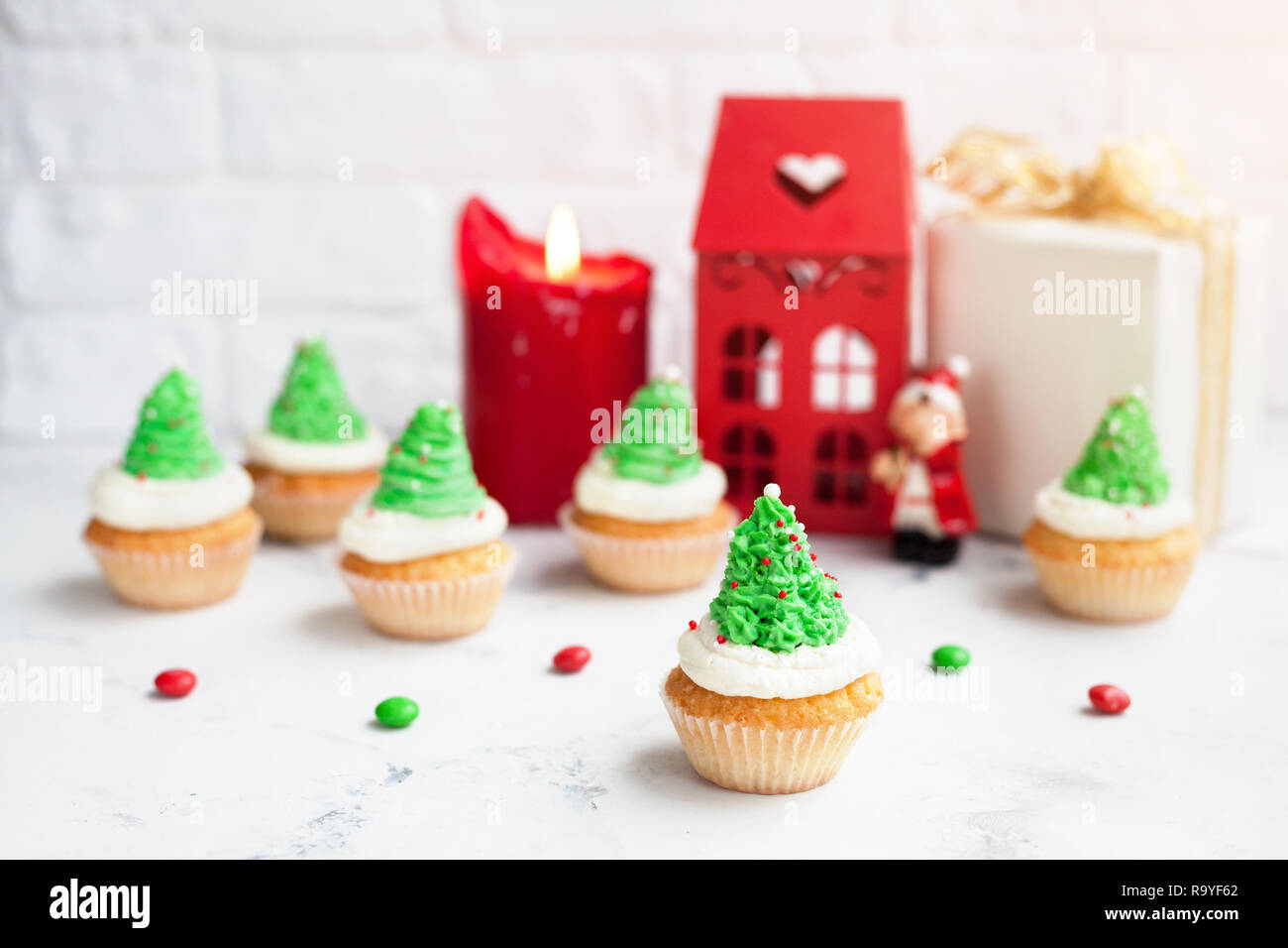 Albero verde tortine vicino casa rossa, candela e presente al tempo di Natale Foto Stock