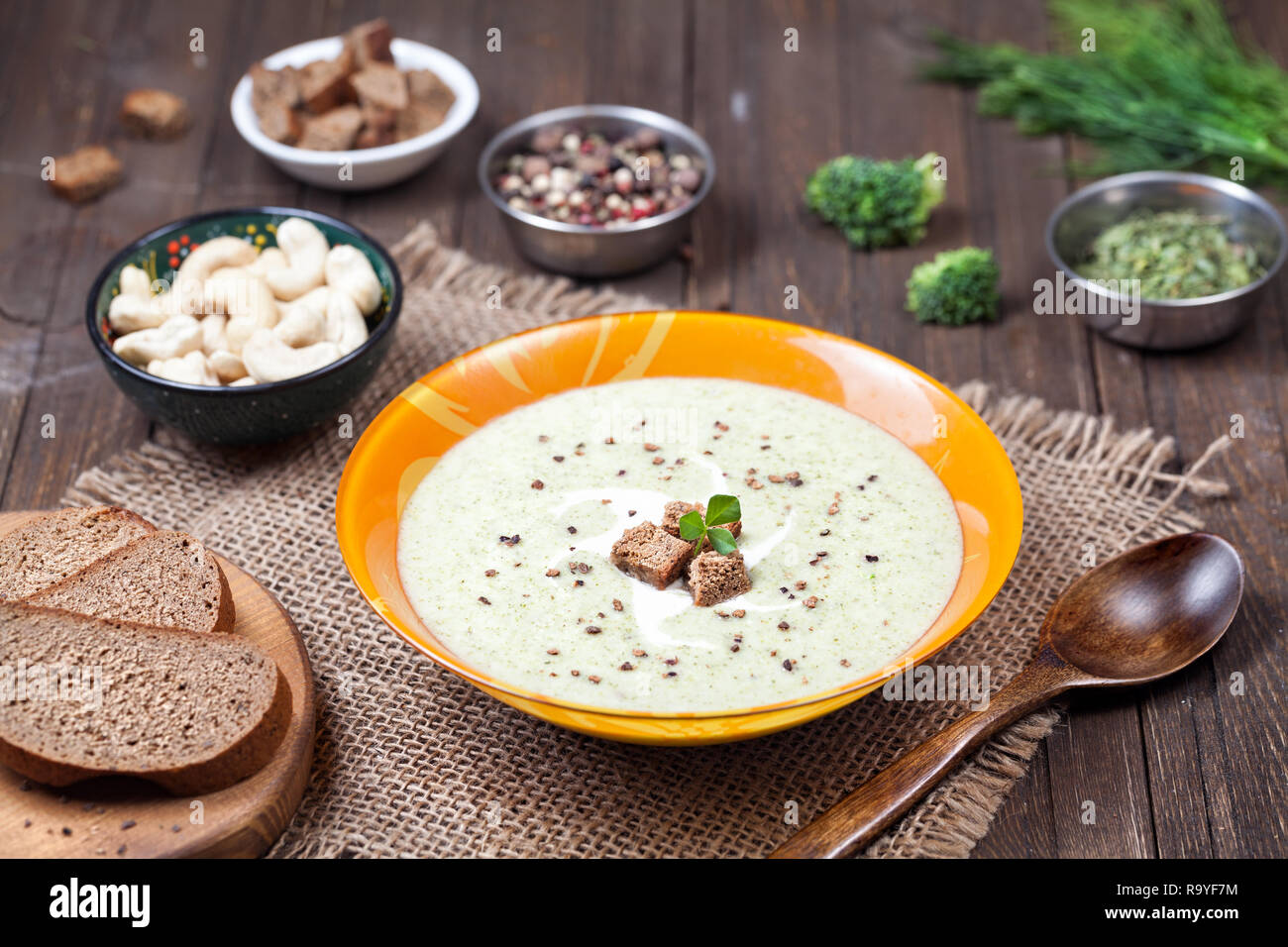 Vegano minestra in crema di broccoli, fieno greco e noci di acagiù su sfondo di legno Foto Stock