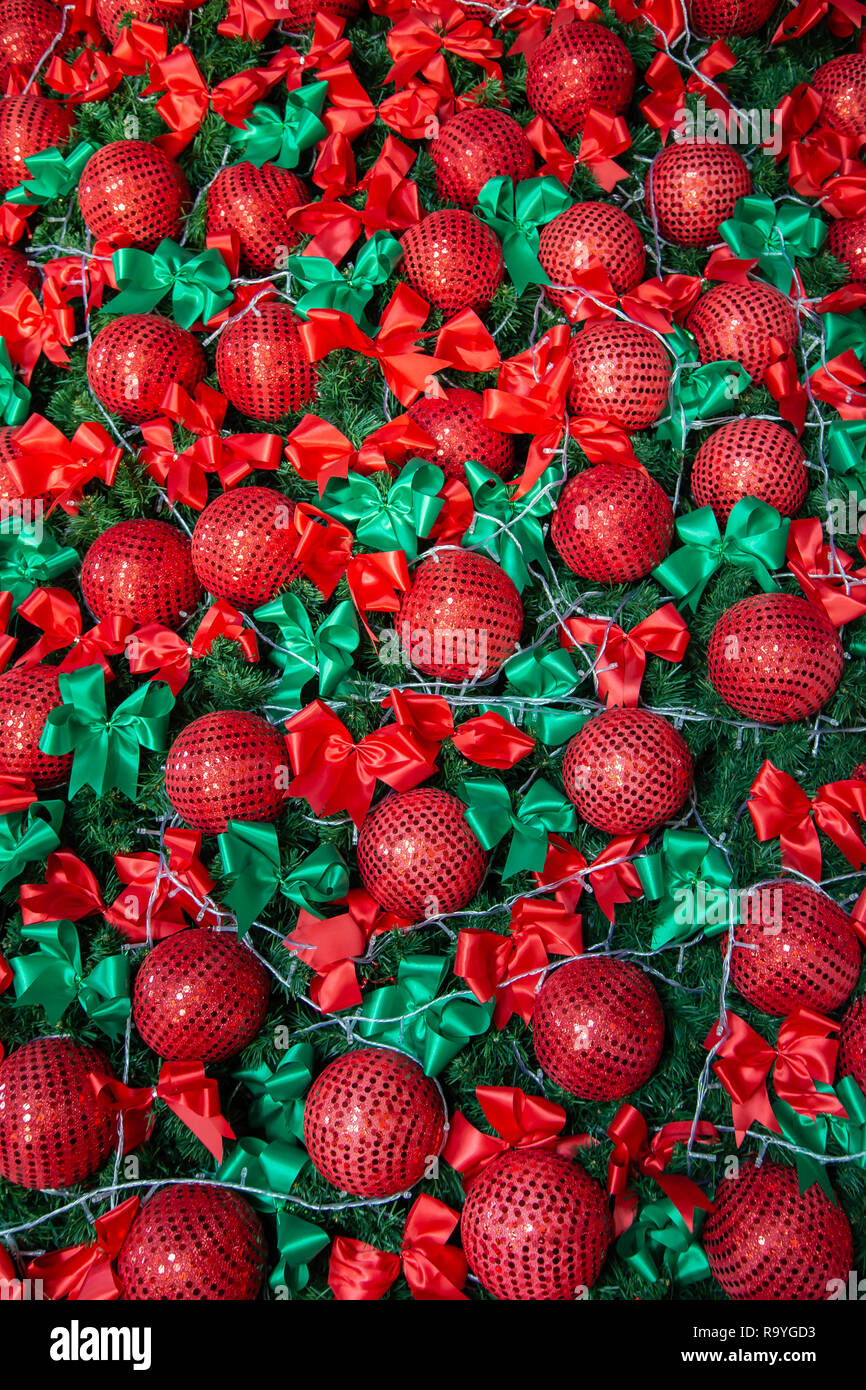 Closeup albero di Natale decorato con sfera rossa e nastro verde Foto Stock