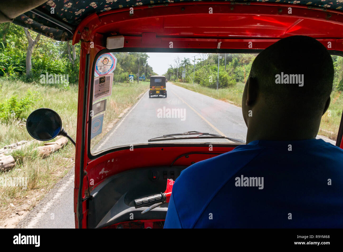 Interno vista lato passeggero di un tuk tuk taxi come si trascina lungo la spiaggia di Diani Road, Kenya Foto Stock