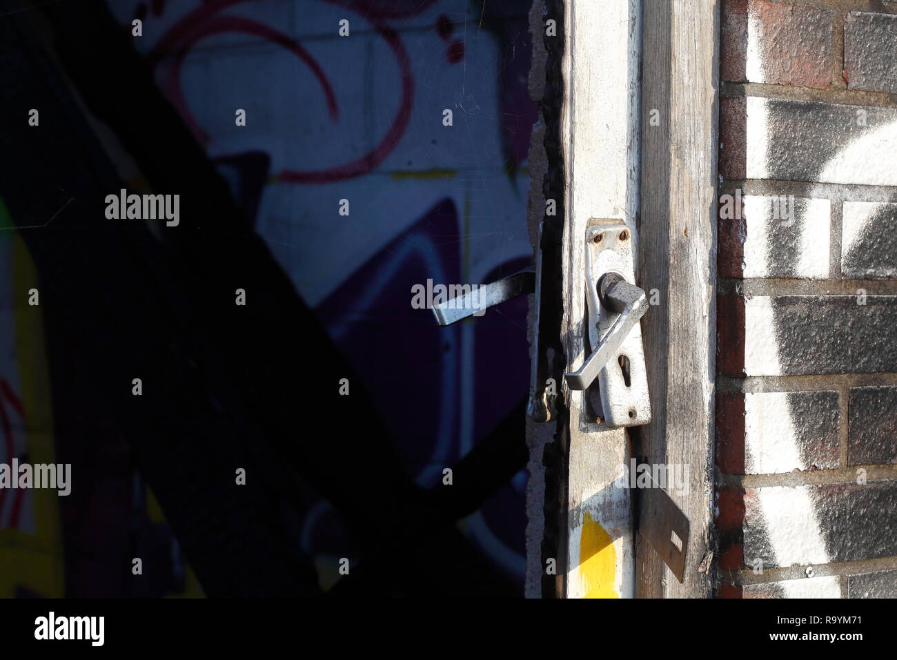 Una porta su un edificio abbandonato , ha una maniglia della porta che assomiglia a una faccia che è noto come Pareidolia. Foto Stock