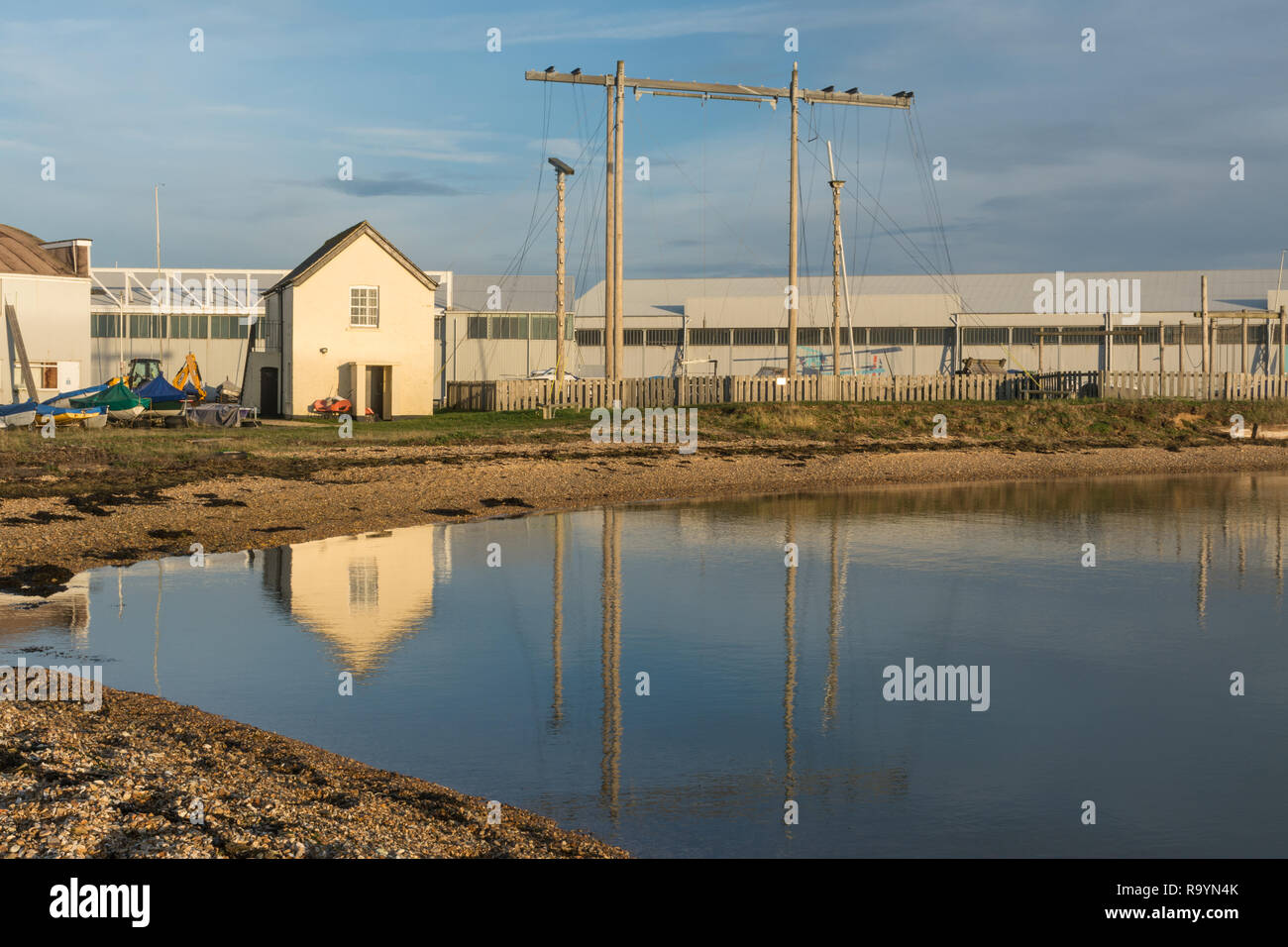 Staniforth Cottage, un edificio classificato Grade II su Calshot spit riflessa nel Solent. Era un edificio di guardia costiera, convertiti in uso militare. Foto Stock