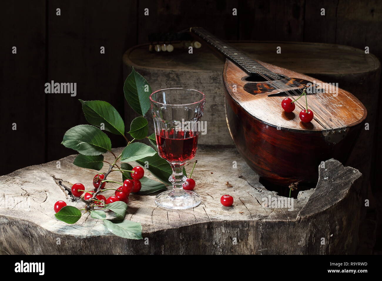 Natura morta con mandolino, vino rosso e ciliegia Foto Stock