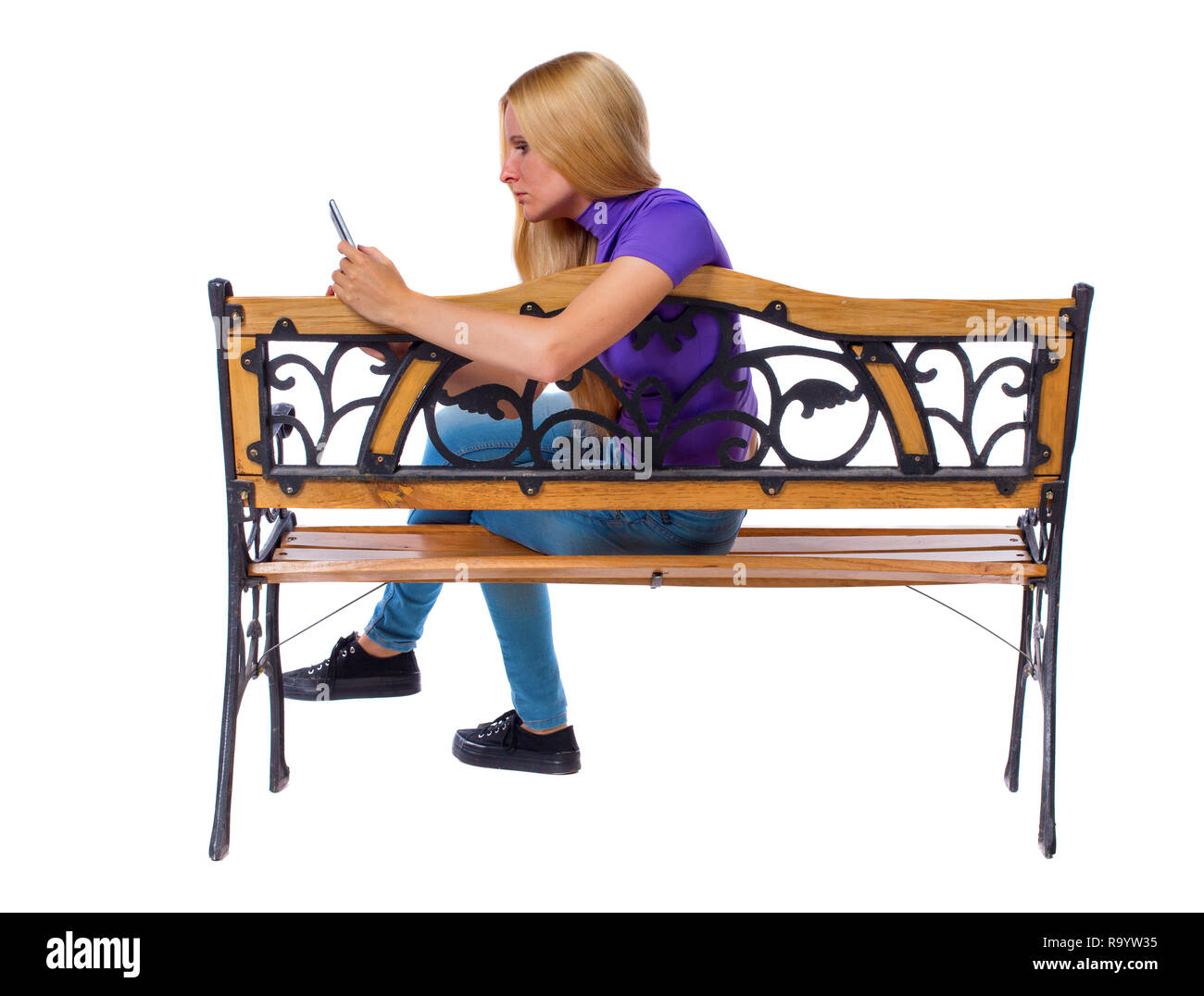 Vista posteriore della donna seduta sul banco e guarda lo schermo del tablet. Vista posteriore di raccolta persone. vista posteriore di persona. Isolato sulla Pentecoste Foto Stock