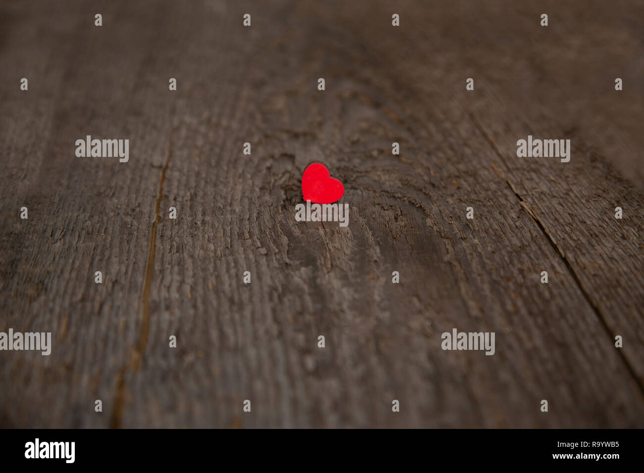 Piccole casette di legno cuore rosso su un vecchio legno secco board per il giorno di San Valentino close up Foto Stock