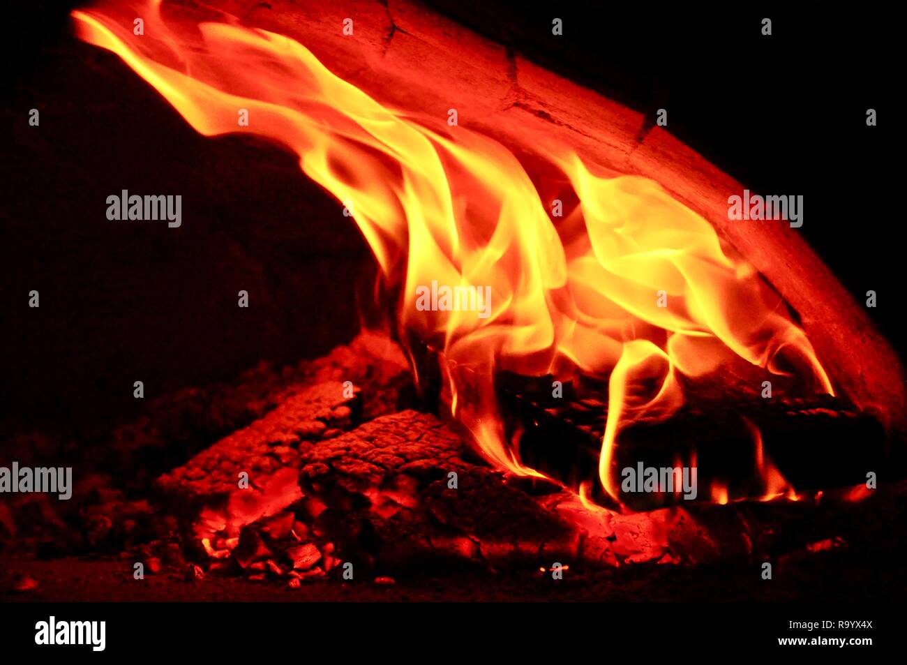 Legno in fiamme di un accogliente caminetto Foto Stock