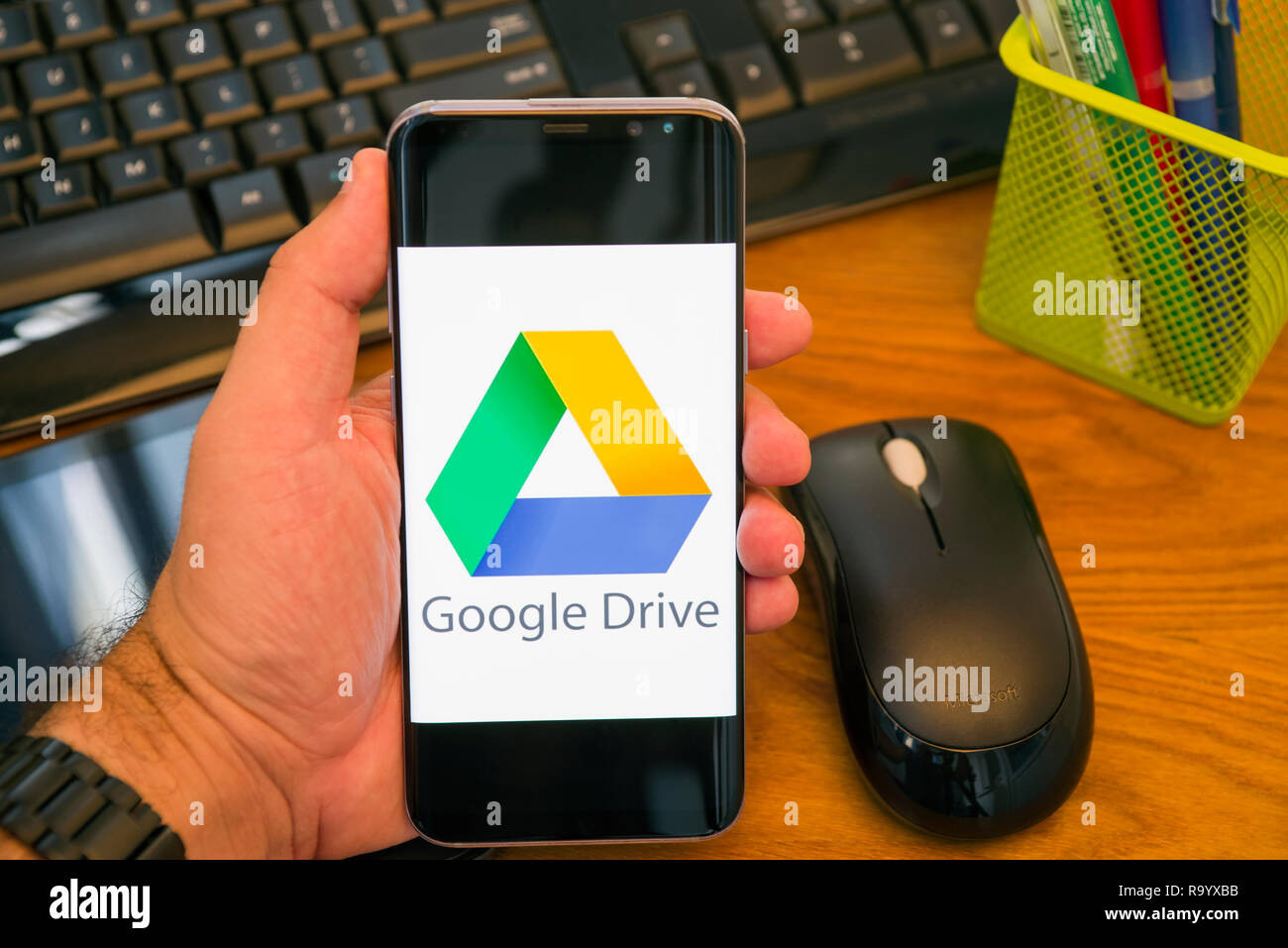 PIATRA NEAMT, Romania - 30 luglio 2018: mano trattiene un Samsung S8+ con Google drive logo sullo schermo, Ufficio dello sfondo. Foto Stock