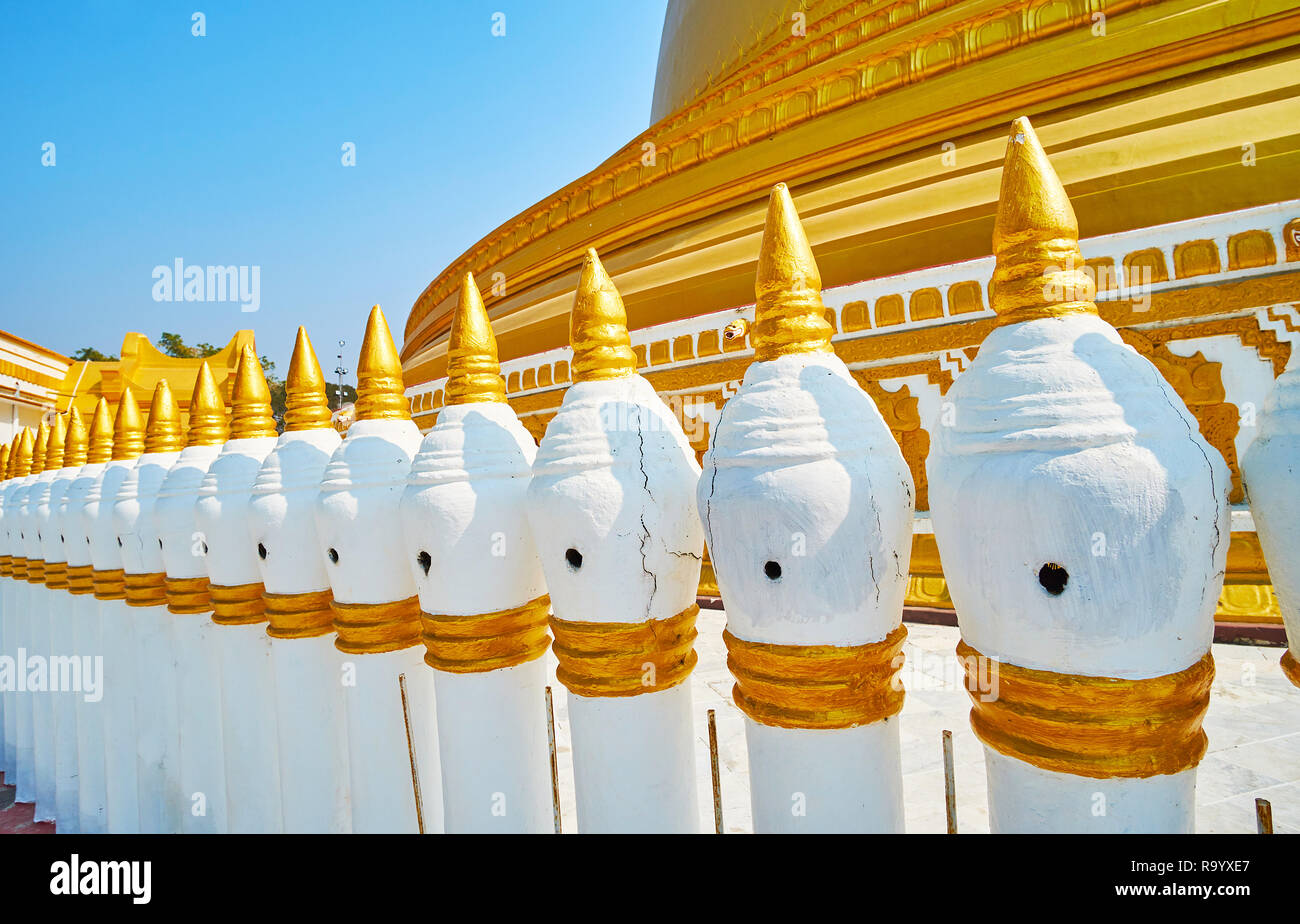 Le colonne del recinto decorativo di Yaza Mani Sula Pagoda Kaunghmudaw sono sormontate da stupa dettagli sagomato con guglie dorate, Sagaing, Myanmar. Foto Stock