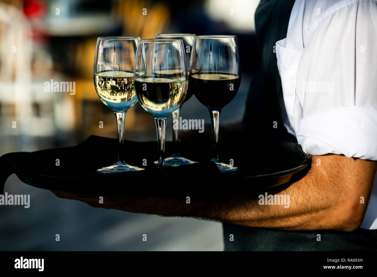 Cameriere sta tenendo in mano un bicchiere di vino rosso e bianco. fantasia e gli eventi di lusso. Foto Stock