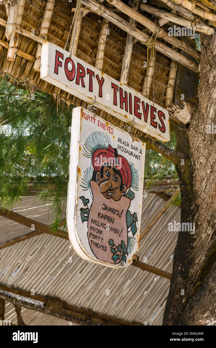 Un segno per il Forty Thieves beach bar e ristorante è appeso a un albero in ombra in una giornata di sole, Diani, Kenya Foto Stock