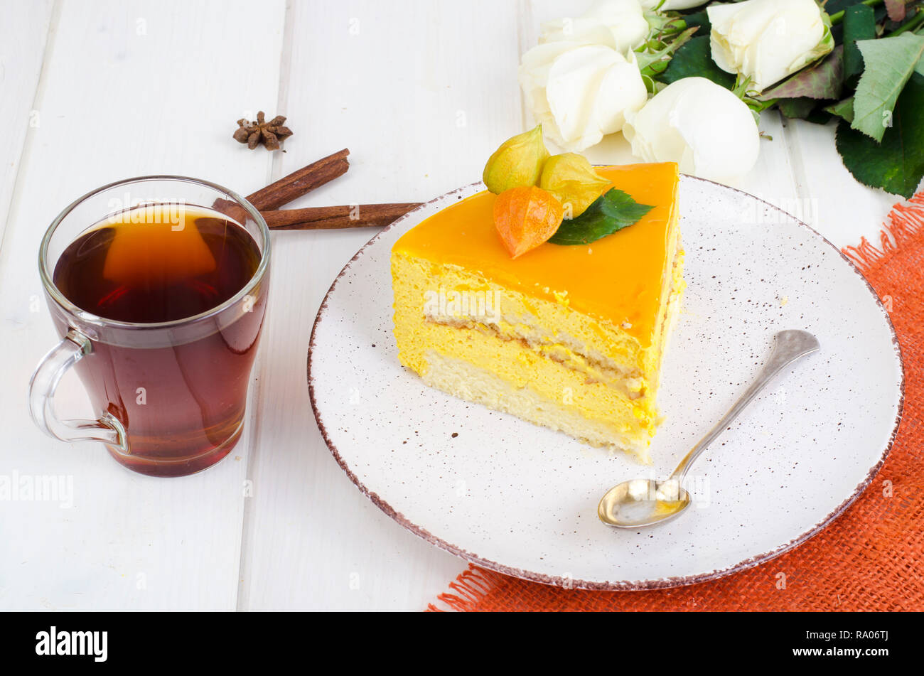 Pezzo di mango mousse sulla piastra, bianco tavolo in legno. Foto Studio Foto Stock