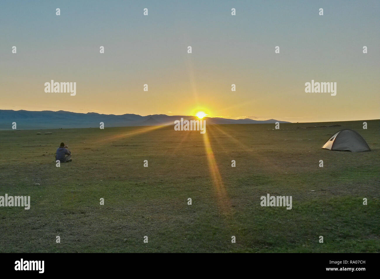 Tramonto sul campeggio solitario nella steppa Mongola con tenda e fotografo, Bulgan, Mongolia Foto Stock