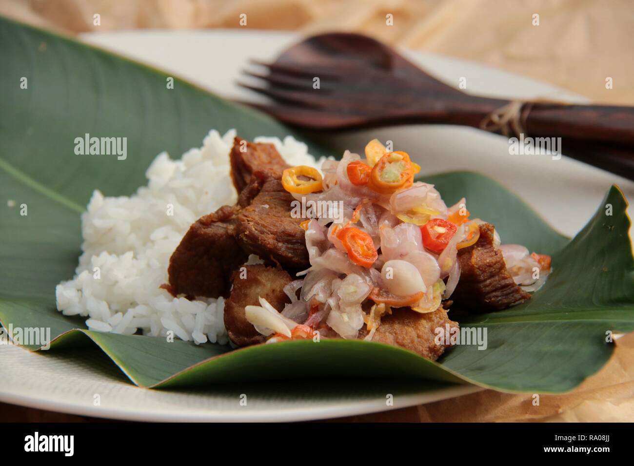 Babi Goreng Sambal Matah. Piatto Balinese di maiale fritto a cubetti con salsa fresca di scalogno e citronella. Foto Stock