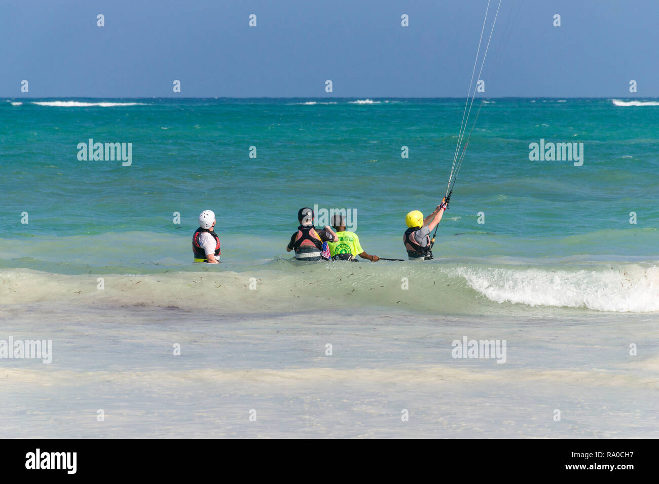 I turisti con istruttore learning per kitesurf nell'Oceano Indiano da la spiaggia di sabbia bianca, Diani, Kenya Foto Stock