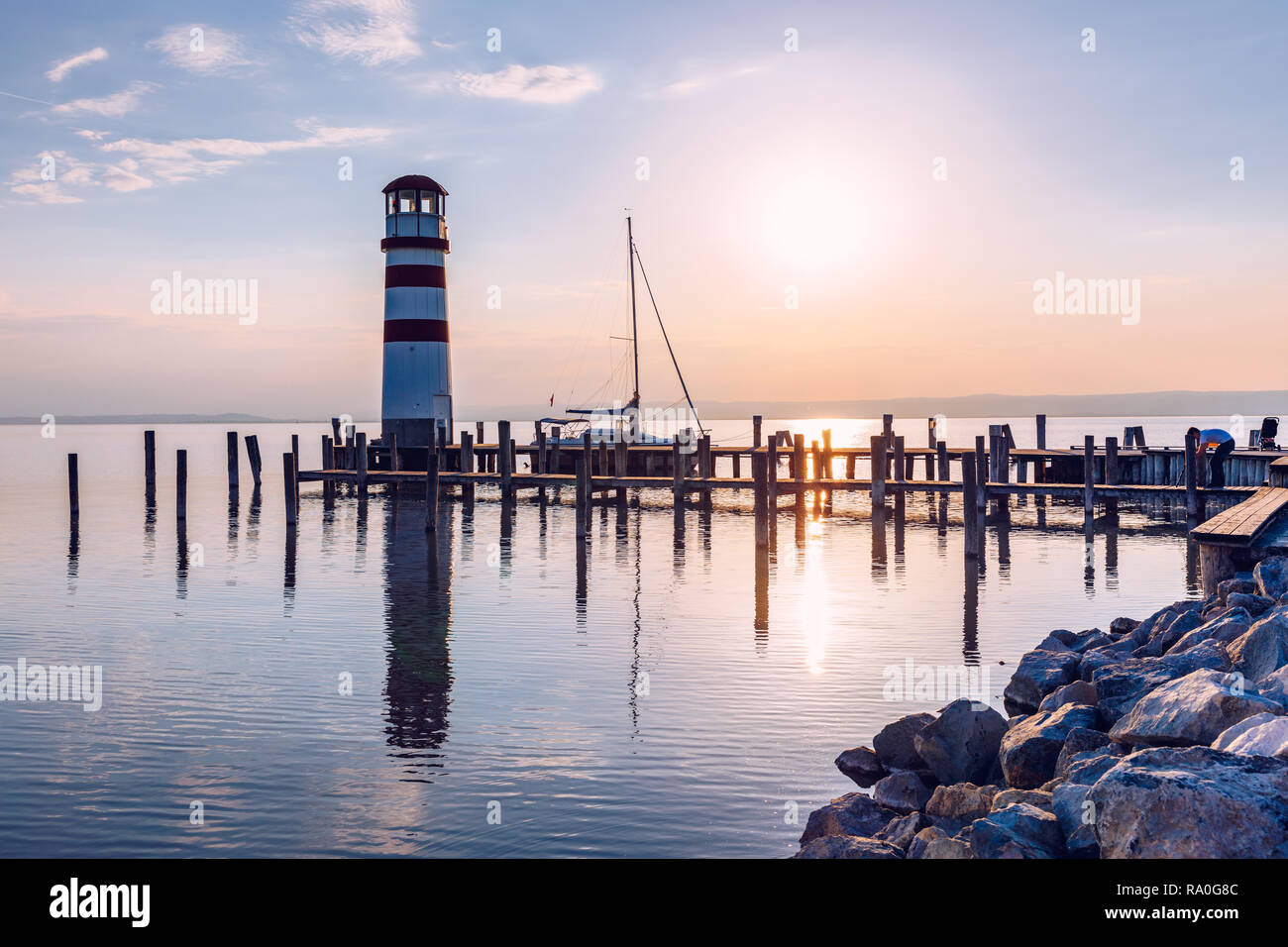 Faro di lago di Neusiedl, Podersdorf am See, Burgenland, Austria. Faro al tramonto in Austria. Il molo di legno con il faro in Podersdorf sul lak Foto Stock