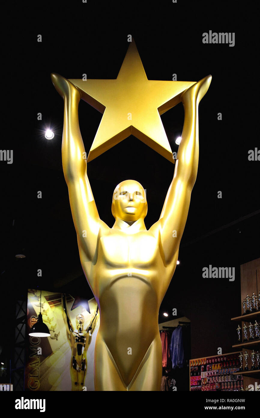 Hollywood, CA/ Stati Uniti d'America - 26 Luglio 2018: Golden Oscar statua holding stella d'oro. Golden award o trofeo è simbolo di successo e il concetto di vittoria Foto Stock
