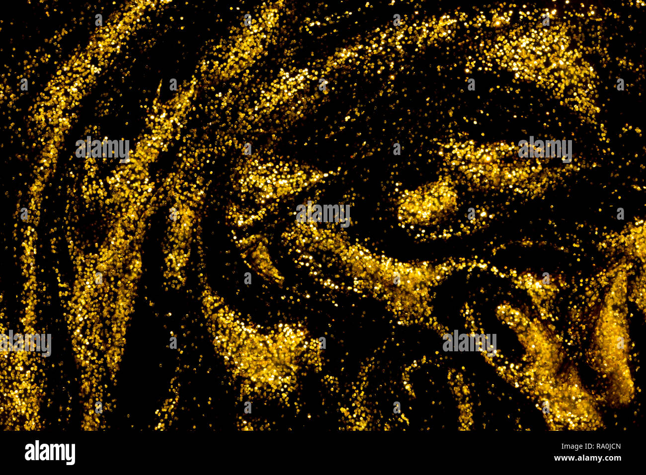 Abstract di sfondo nero e oro metallizzato vernice glitter volute Foto Stock